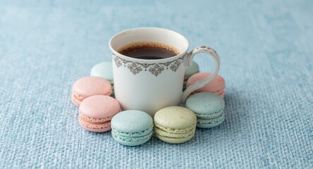 Visual harmony of a gourmet coffee cup with pastel macarons on a soft blue textured background