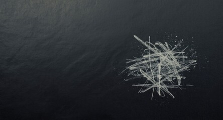 White pencil marks on dark textured paper backdrop with copy space