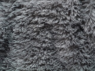 Top view of grey faux fur texture background with long hair fibers. Ideal for fashion, interior design, or winter-themed backgrounds © Eka