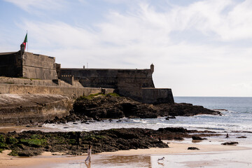 Historic coastal fortress above rocky beach in Cascais