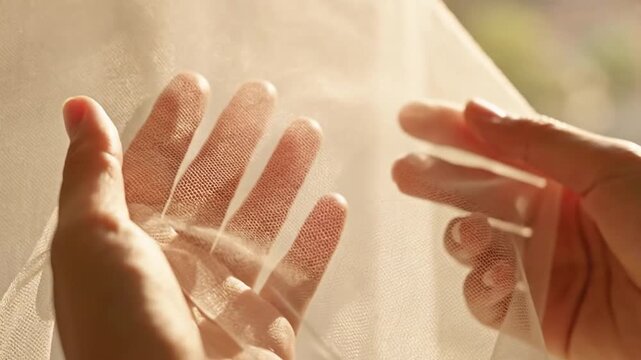close up of hand holding white mosquito net fabric, malaria prevention concept