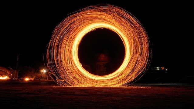 Long-exposure shot of a fire spinner creating a glowing ring of sparks at night. Concept Long-exposure photography, Fire spinner, Night scene, Spark ring, Motion blur