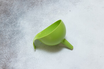 Naklejka premium Green plastic funnel kitchen tool warm closeup