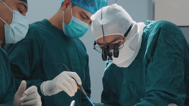 Surgical team working together during a medical operation. Sterile environment and focused teamwork inside a hospital operating room. Professional healthcare teamwork transplantation plastic surgery 