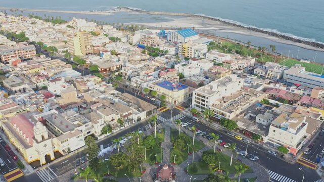Aerial view flying backward from plaza matriz in la punta district, revealing the callao coastline