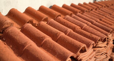 Stack of unglazed clay roof tiles arranged for sale