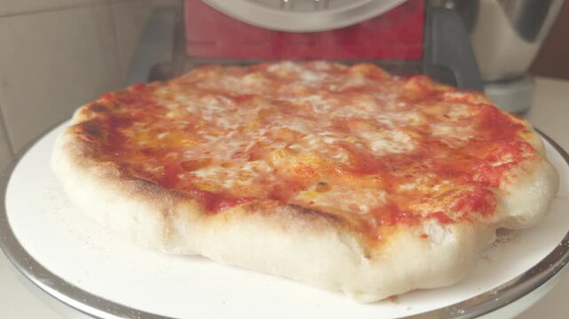 Rotating shot of homemade pizza baking in a round domestic oven. 