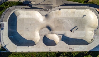 Overhead view of an empty skate park bowl with people