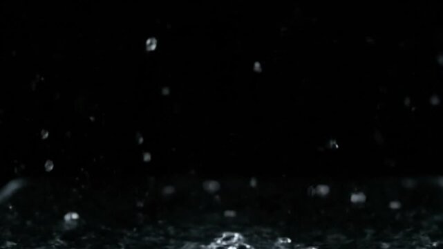 Slow motion explosion of water droplets into the camera lens capturing dynamic liquid motion.