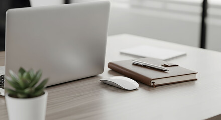 Modern minimalist home office desk with silver laptop, wireless mouse and leather notebook on wooden table. Clean workspace setup with succulent plant and professional accessories