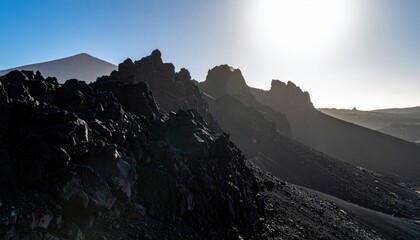 Obraz premium Dramatic Craggy Volcanic Mountain Slopes Bathed in Sunlight, Showcasing Rugged Terrain