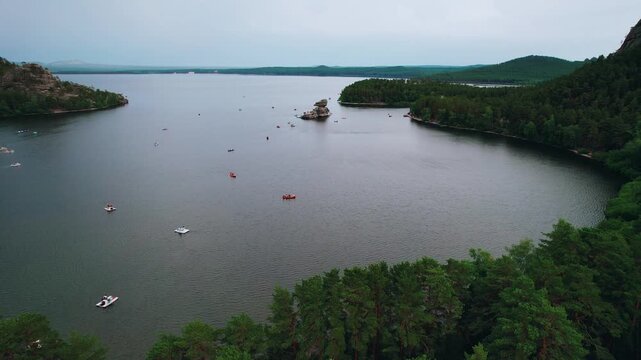 Beautiful landscape of tranquil lake with boat, forests and rocky mountains. Aerial view National nature park Burabay, Kazakhstan.