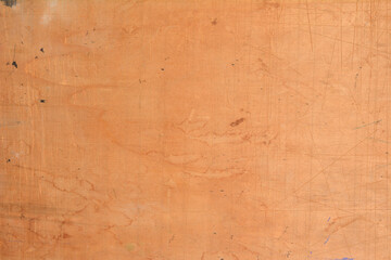 Obraz premium A close up view of a brown plywood surface with numerous scratches and light stains creating a worn industrial wood texture