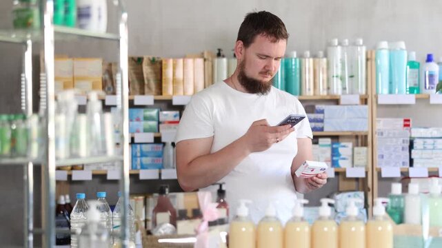 Young man buyer scanning qr code for box of paracetamol tablets in pharmacy