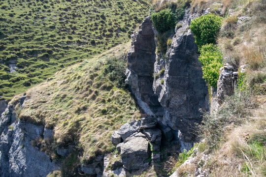 Vista de una gran formaci&oacute;n rocosa con una grieta central en una ladera cubierta de hierba en Burgos, Espa&ntilde;a