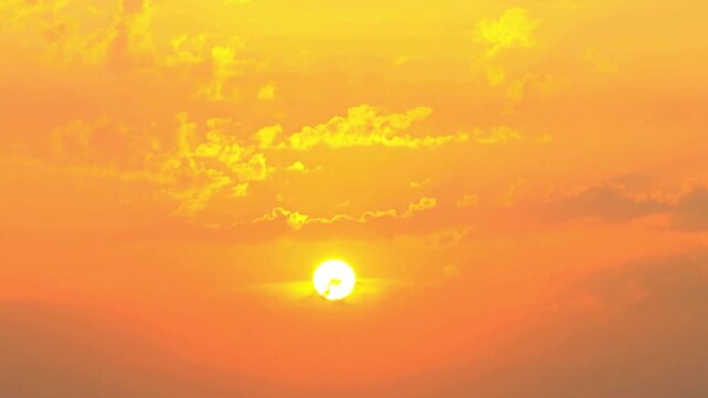 Golden sunset with sun glowing through orange clouds at dusk. travel vlogs, and nature documentaries.