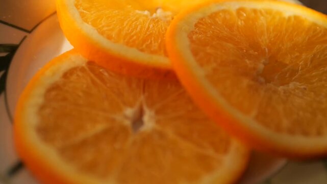 close-up of fresh orange slices on a plate - Detailed view of organic orange slices in smooth slow-mo, highlighting fresh citrus pulp and juice vesicles