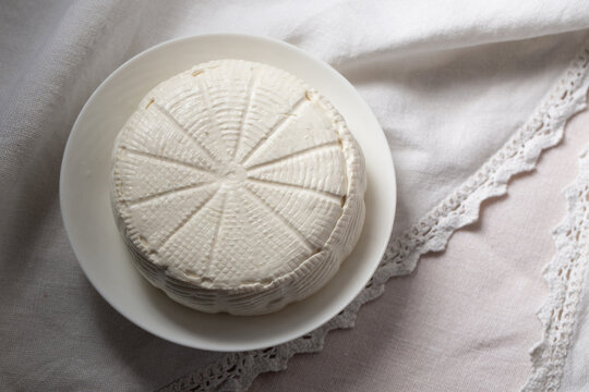 A head of goat cheese bryndza in a plate, top view