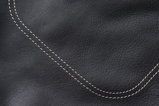 Black leather texture. Light thread stitched on black leather
