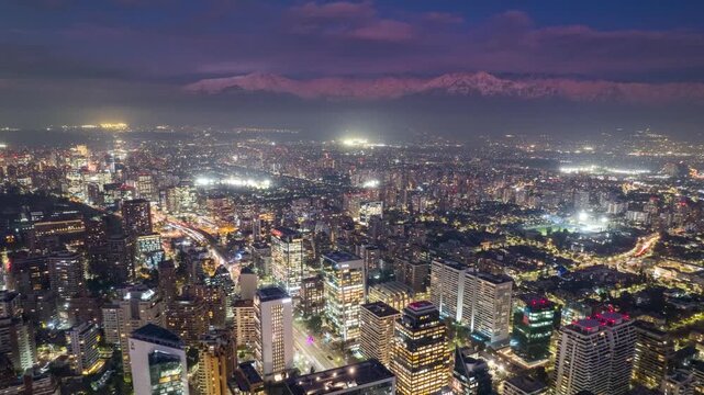 Santiago, Chile &ndash; July 2023: Hyperlapse drone flight advancing over El Golf district in Las Condes, showing illuminated skyscrapers and the Andes Mountains at night.