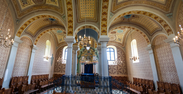 Jewish architectural design in a synagogue interior featuring ornate details and wooden seating in Hungary