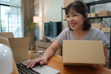 Asian woman working on laptop for online business at home