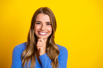 Fototapeta premium Young smiling woman in blue top posing against bright yellow background for fashion lifestyle stock photo