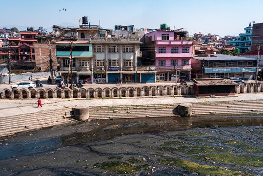 Colorful buildings overlooking the polluted Bagmati River with stone ghats along the banks near the Pashupatinath complex in Kathmandu, Nepal