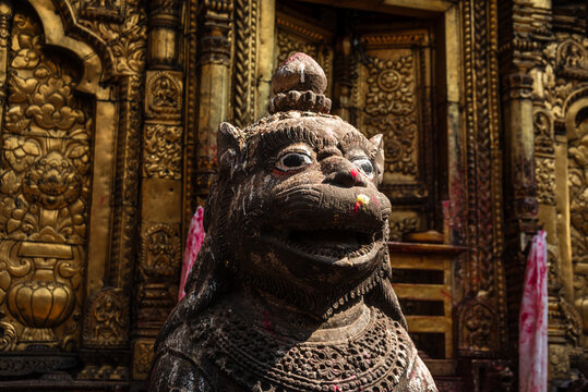 Stone lion guardian statue with intricate carvings at the entrance of Changu Narayan Temple, a UNESCO World Heritage Site in Nepal