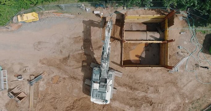 Top view of excavator and shoring box at construction site