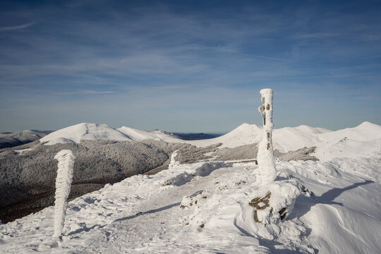Snow covered mountain trail on Tarnica during a cold and frosty winter day in the Polish Bieszczady.
