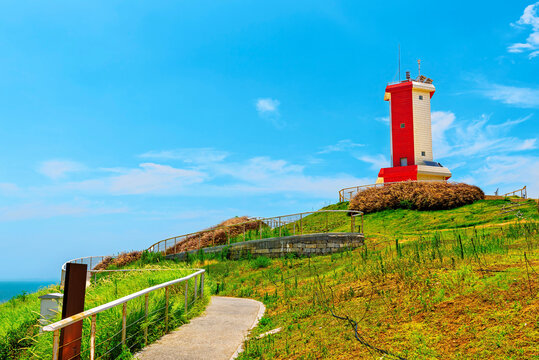 Red and white lighthouse stands on a hill above the sea in Little Weihai, Shishi, Quanzhou, Fujian Province, China