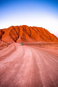 4x4 car driving among the red volcanic rocks and mountains in the Labyrinth Desert, Salta province, Puna, Argentina