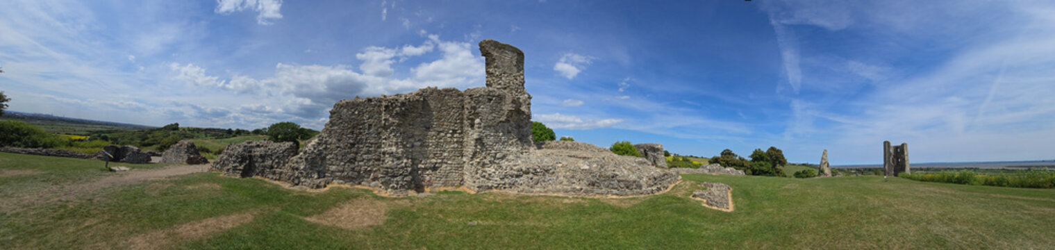 Explore Hadleigh Castle ruins in Essex under a clear sky with green fields nearby and a distant tower