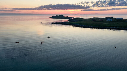 Midnight sun, evening, night. Amazing pink, orange sky, with reflection in the water of the sea, ocean. Some small rocky islands. Adventure. Beautiful nature in arctic norway. © Dirk