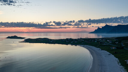 Midnight sun, evening, night. Amazing pink, orange sky, with reflection in the water of the sea, ocean. Some small rocky islands. Adventure. Beautiful nature in arctic norway. © Dirk