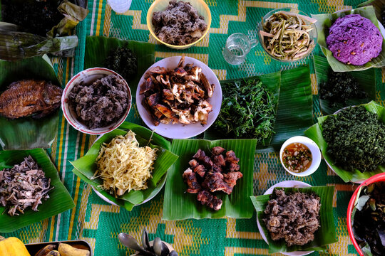 Traditional festive meal in a village on the highlands. Rice cooked over a wood fire in a bamboo pot. Kontum. Vietnam.