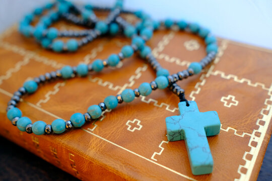 Old holy bible with a leather cover and a Rosary.