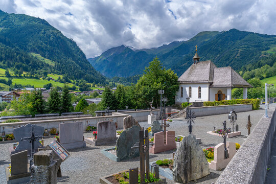 View of chapel and graveyard with mountains in background on a sunny day, Kaprun, Salzburg, Austria, Europe