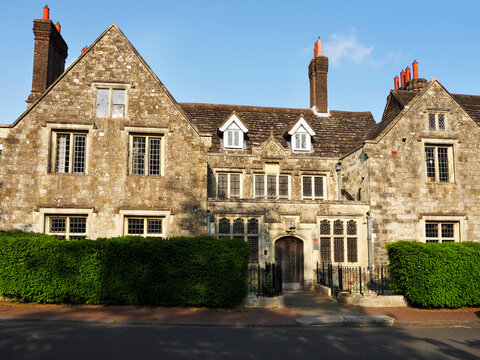Historic Southover Grange building in Lewes East Sussex with stone walls and manicured hedges in the front during daylight hours