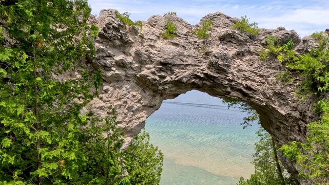 Arch Rock Natural Landmark. The iconic 146-foot Arch Rock towering above Lake Huron. A limestone masterpiece sculpted by water and ice over millennia, located within the lush, historic state park.