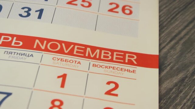 Close up paper calendar with pages turning and months changing, showing month names, date tracking, scheduling, planning, business organization, time management concept