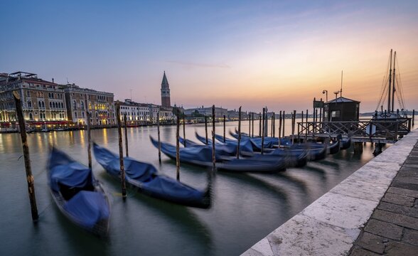 Venetian gondolas, boat dock at the customs office on the Grand Canal, Gondola Traghetto Dogana, Campanile behind, long exposure at sunrise, Venice, Veneto, Italy