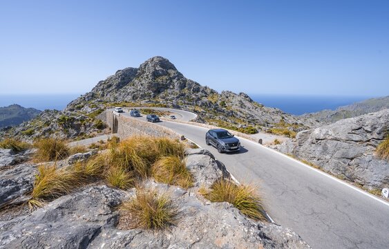 Car at the mountain pass with switchbacks to Sa Colobra, Nus de Sa Corbata road loop, Serra de Tramuntana, Majorca, Balearic Islands, Spain