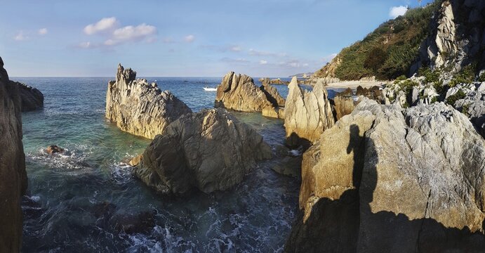 Craggy rocks jutting out of the sea on the beach of Lido La Scogliera, Tropea, Vibo Valentia, Calabria, Southern Italy, Italy