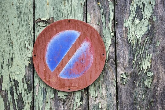 Old no stopping sign on weathered wooden wall, Provence, France