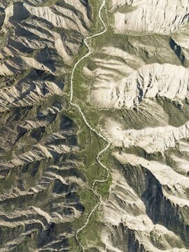 Dirt road in the Gorafe Desert with green surroundings after some rainfalls, aerial view, drone shot, UNESCO Granada Geopark, Granada province, Andalusia, Spain