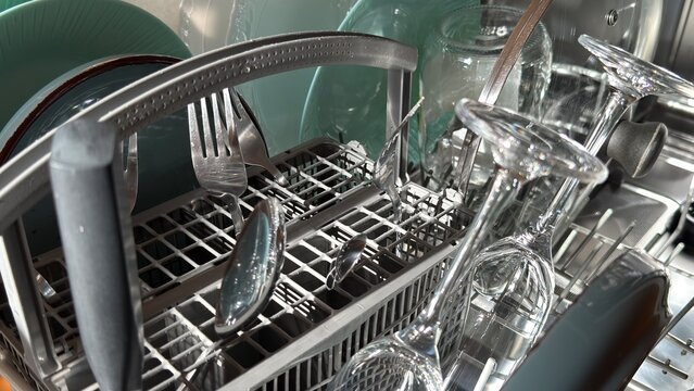 Dishwasher finished cycle, cleaned plates white blue, home real UGC shot, cutlery glasses mug cup kitchen sparkling 