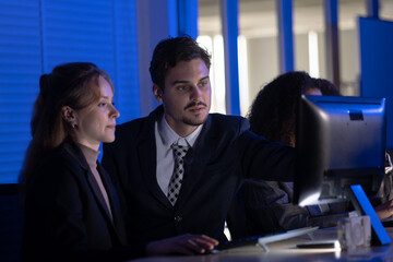 Group working late in an office with focus on teamwork and collaboration at night during a project meeting