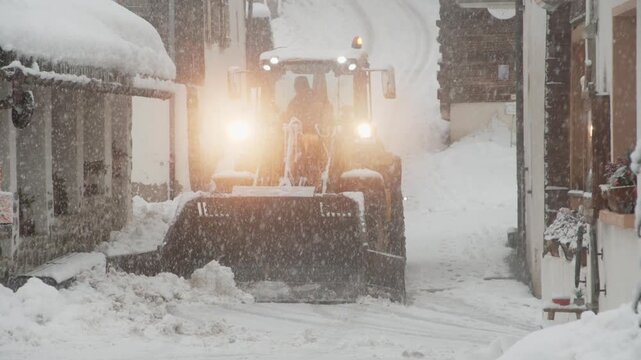 Chasse neige dans une ruelle de village de montagne